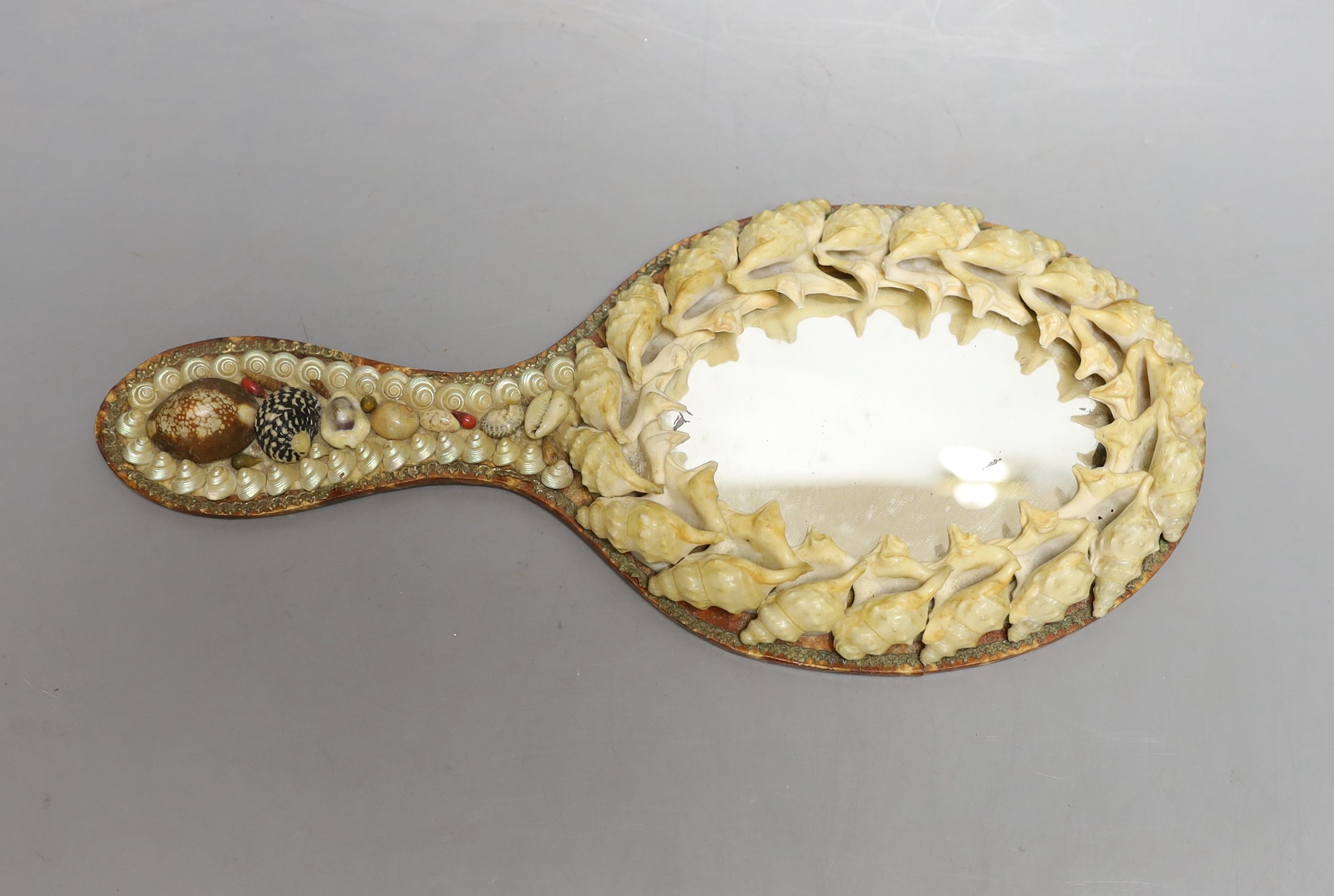 A shell mounted star with central scenic seascape and a shell hand mirror, star 24 cms wide.